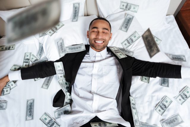 How to Make Extra Money African man lying on bed with falling money